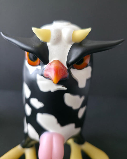Cow-shaped glass rig with a black and white pattern on a dark background