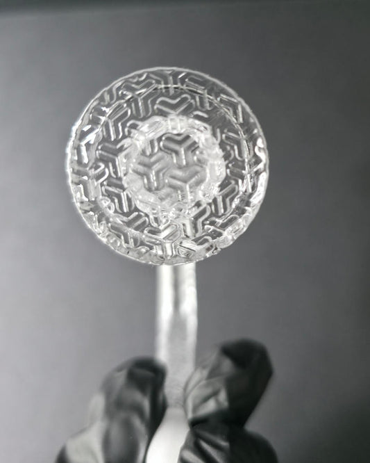 Clear glass quartz banger with embossed design on a dark grey background
