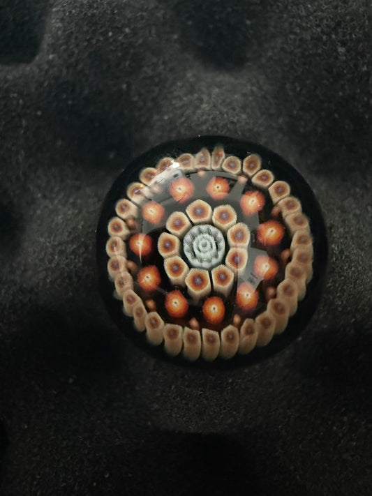 Glass Marble with a pattern design on a textured black background