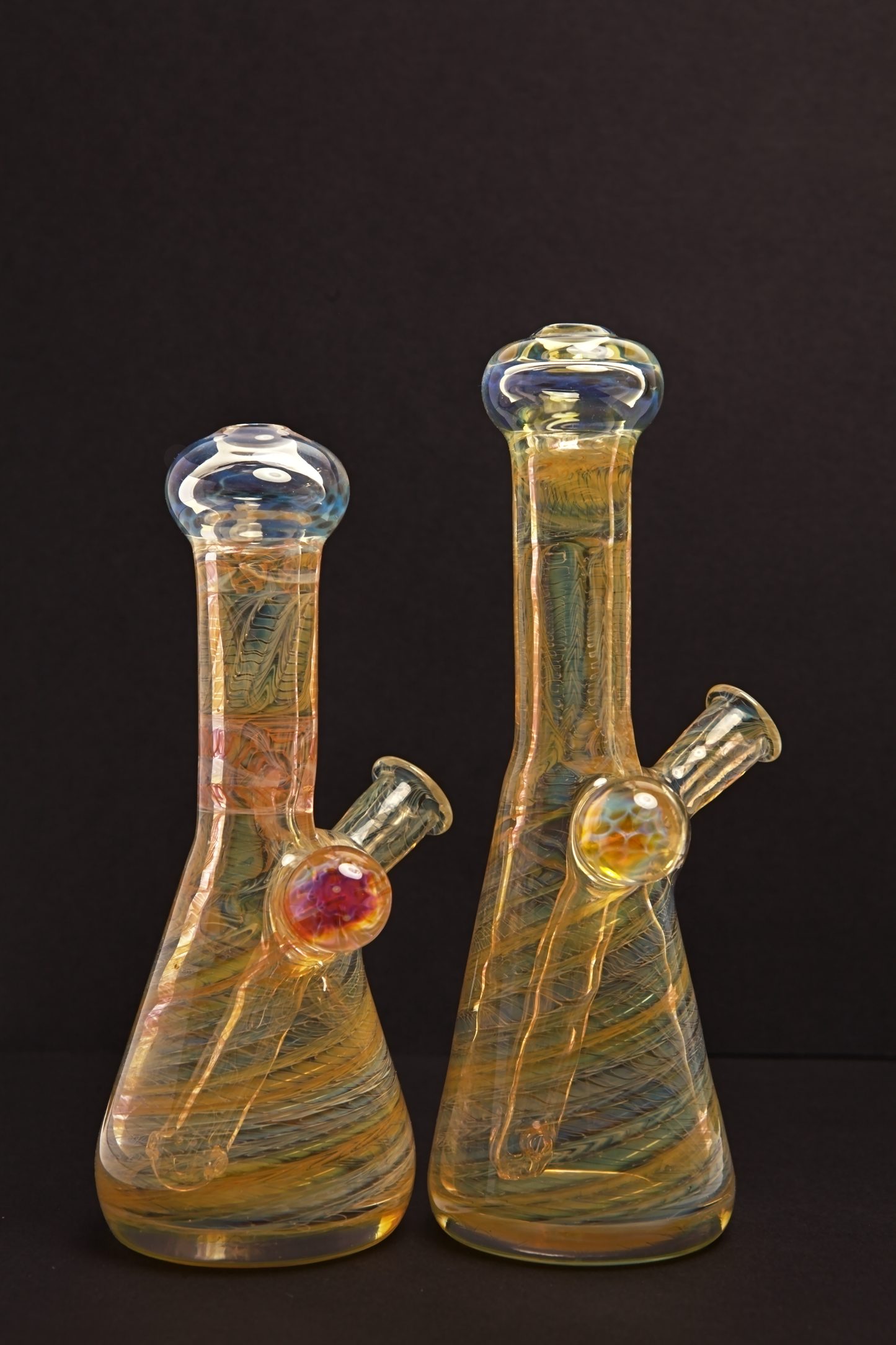 Glass Paradise Two glass beakers with colourful interior patterns on a black background
