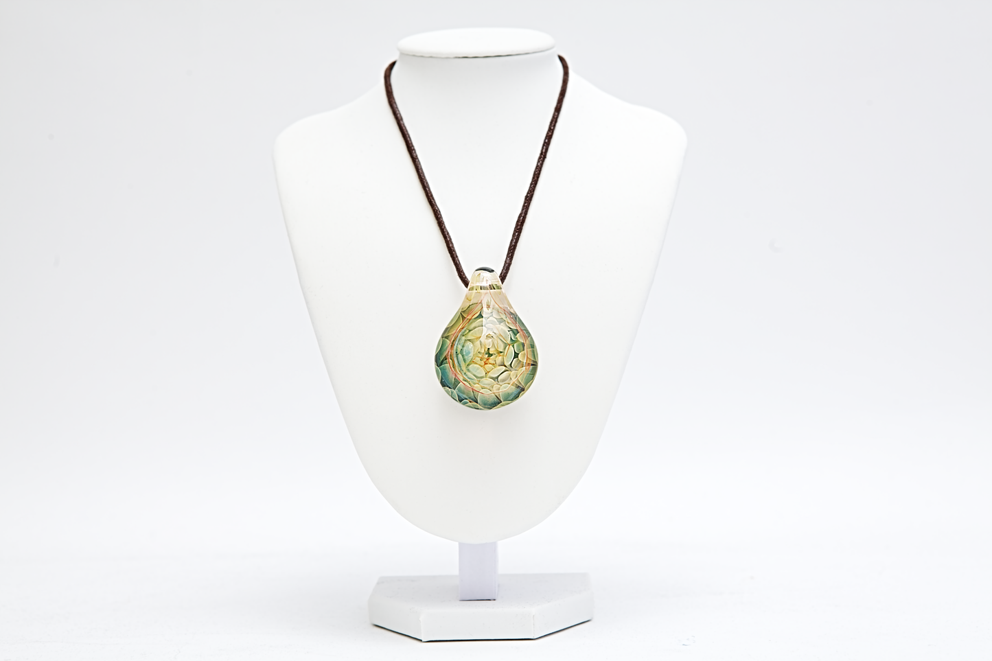 Necklace with a green pendant on a white mannequin bust against a white background