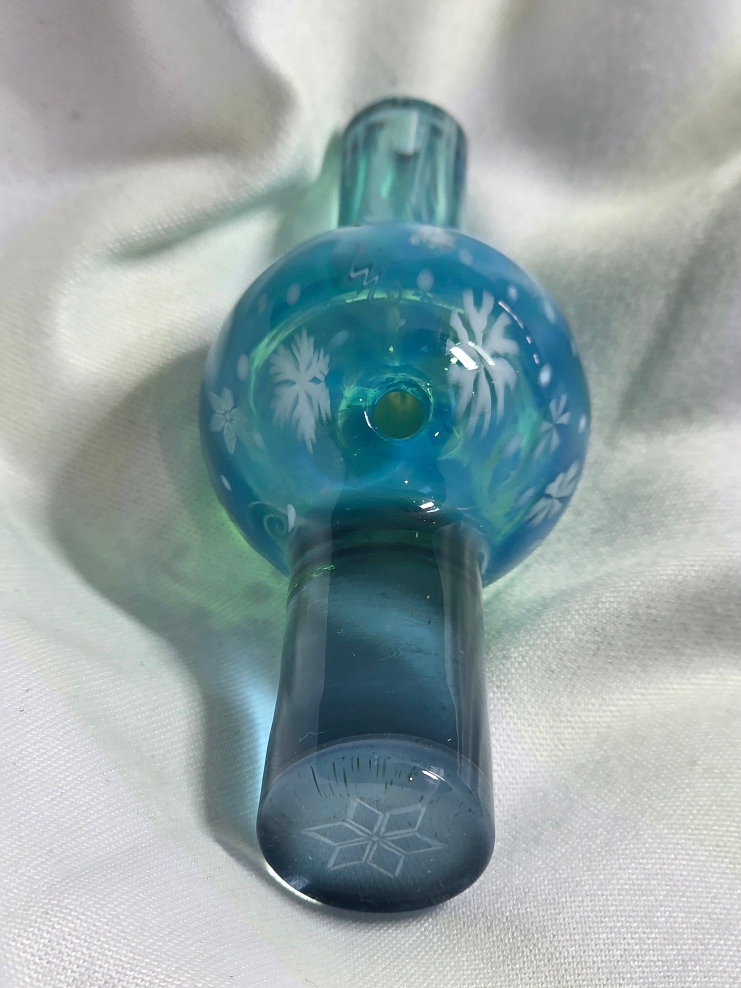 Blue glass top cap with floral design on a white background