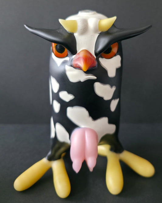 Cow-shaped Robertson glass rig with a black and white pattern on a dark background