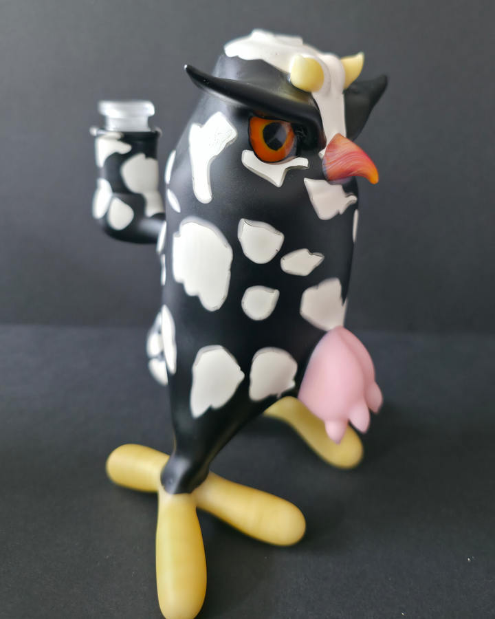 Cow-shaped Robertson glass rig with a black and white pattern on a dark background