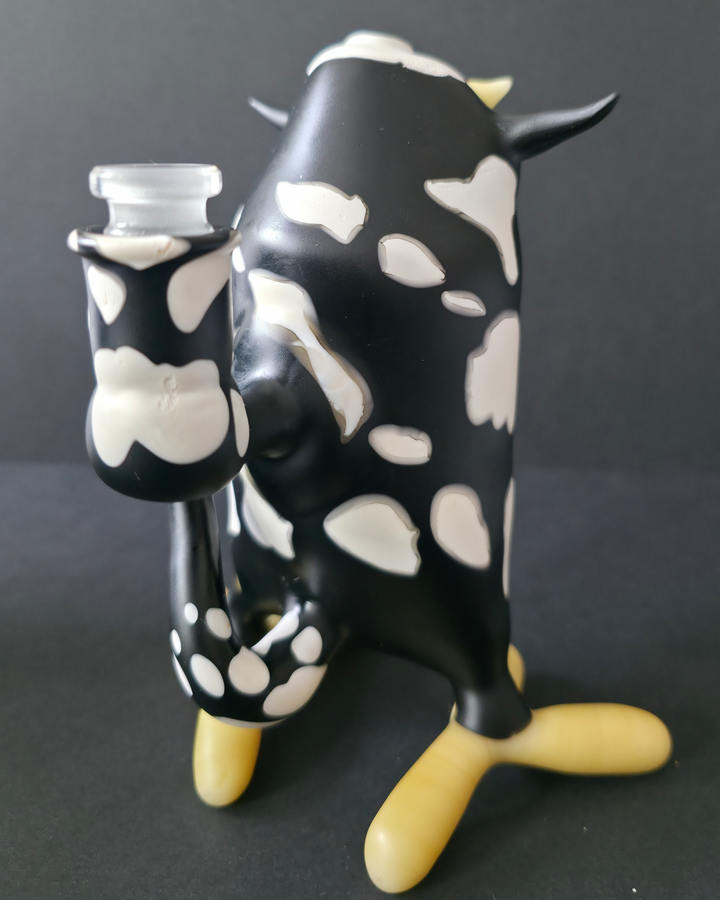 Cow-shaped Robertson glass rig with a black and white pattern on a dark background