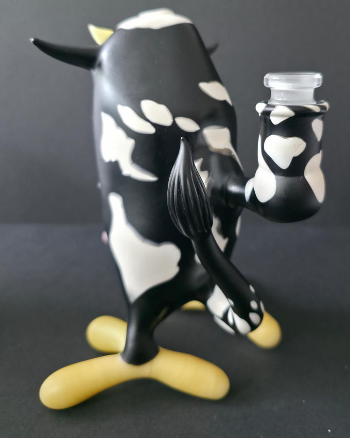Cow-shaped glass rig with a black and white pattern on a dark background