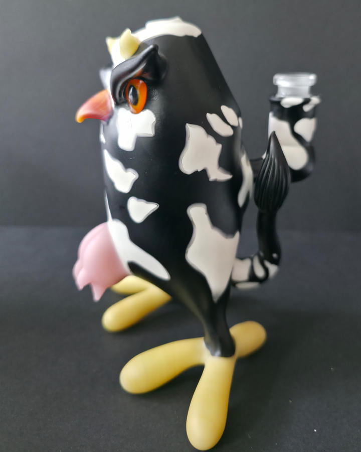 Cow-shaped glass rig with a black and white pattern on a dark background