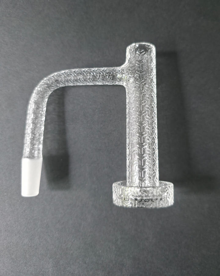 Clear glass quartz banger with embossed design on a dark grey background