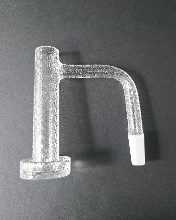 Clear glass quartz banger with embossed design on a dark grey background