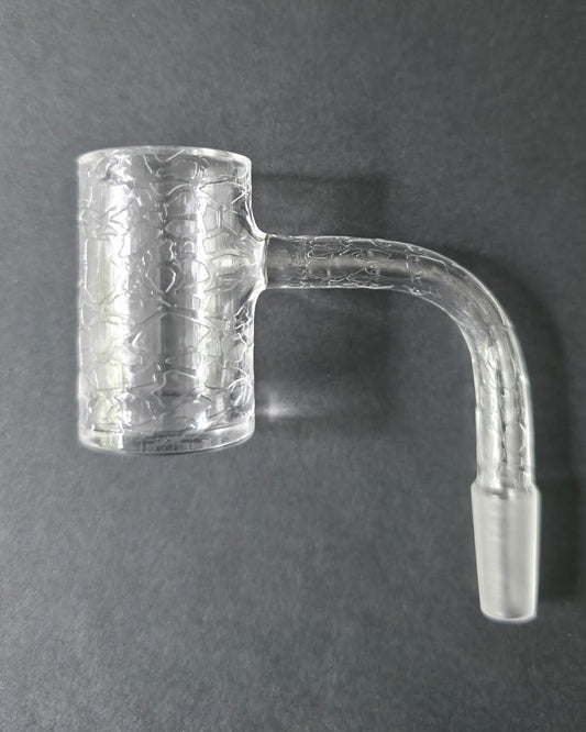 Clear glass quartz banger with embossed design on a dark grey background