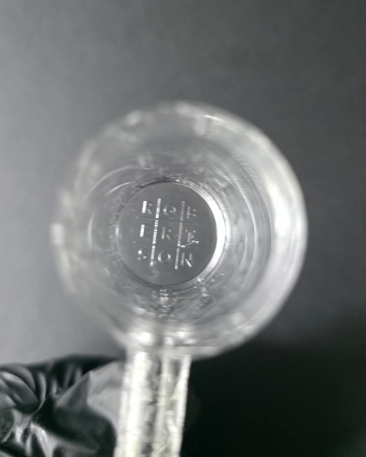 Clear glass quartz banger with embossed design on a dark grey background