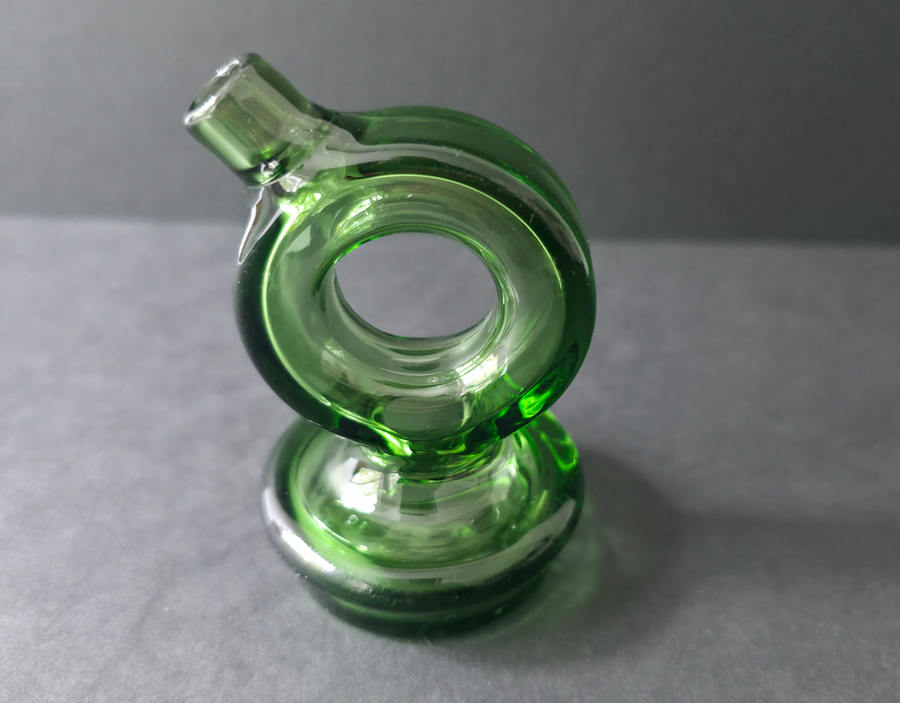 Green glass smoking accessory on a gray background