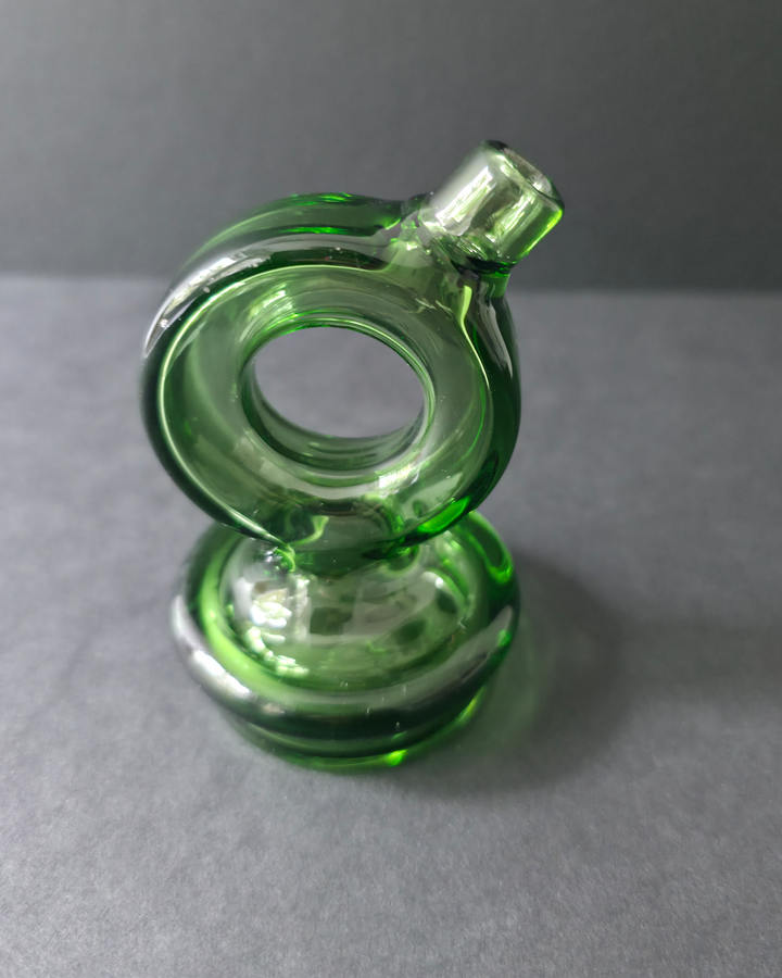 Green glass smoking accessory on a gray background