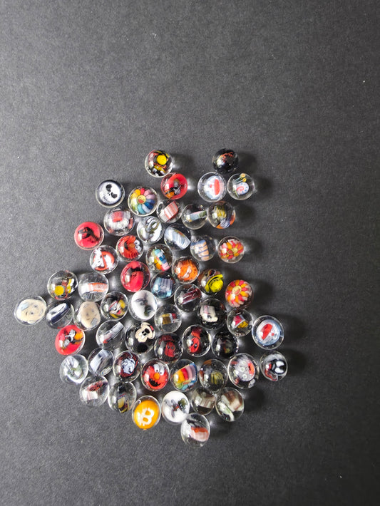 Glass Marbles with a character designs and patterns on a textured black background