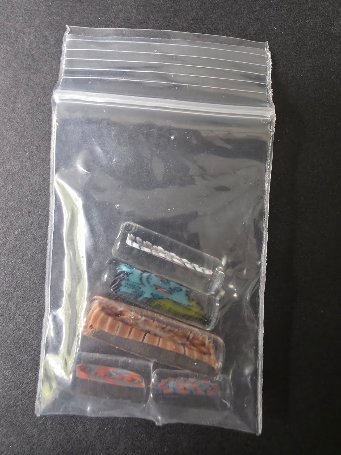 Clear plastic bag with glass pearls used in bangers on a dark background