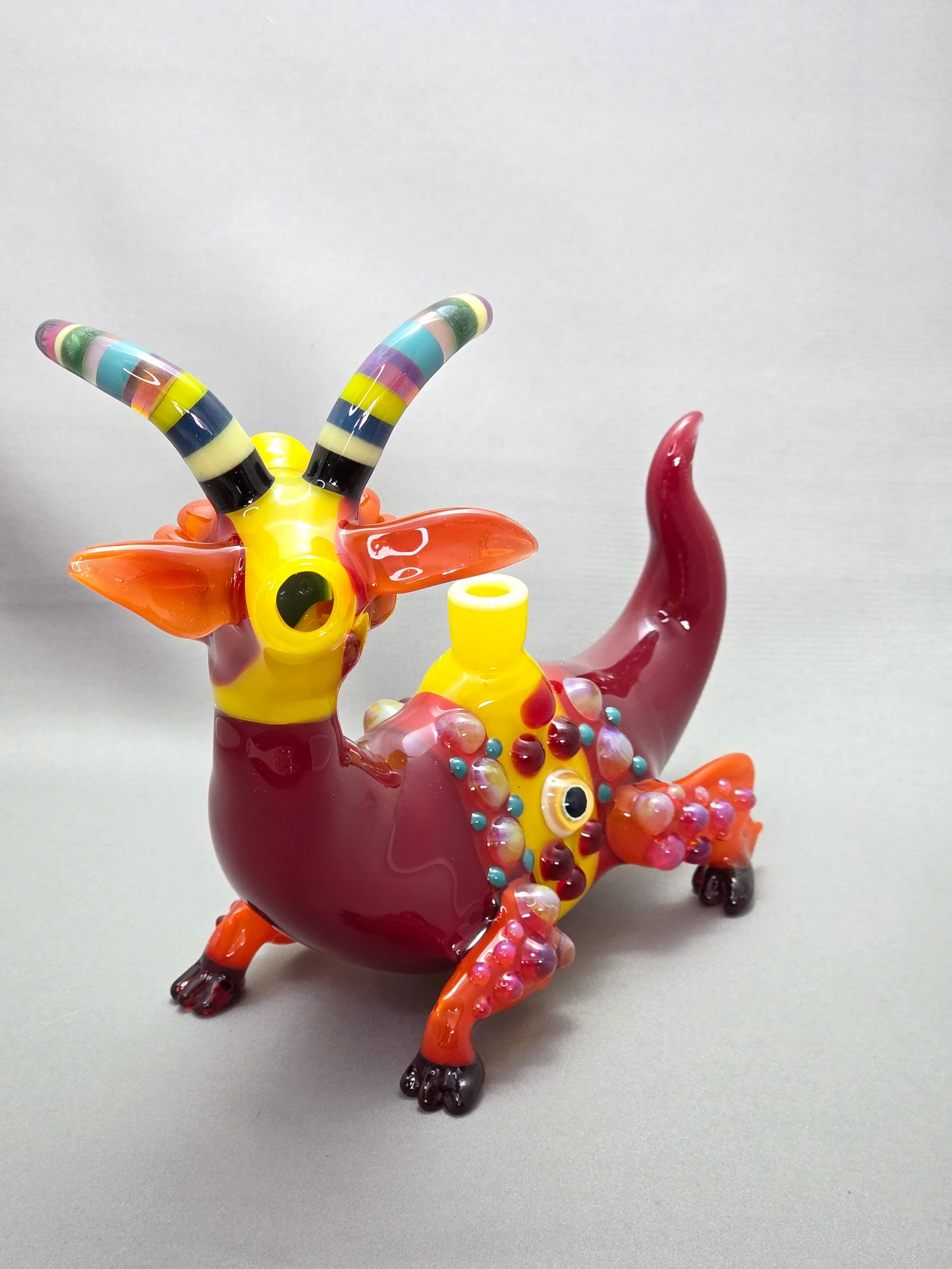 Robertson Glass Colourful glass Goat sculpture on a grey background