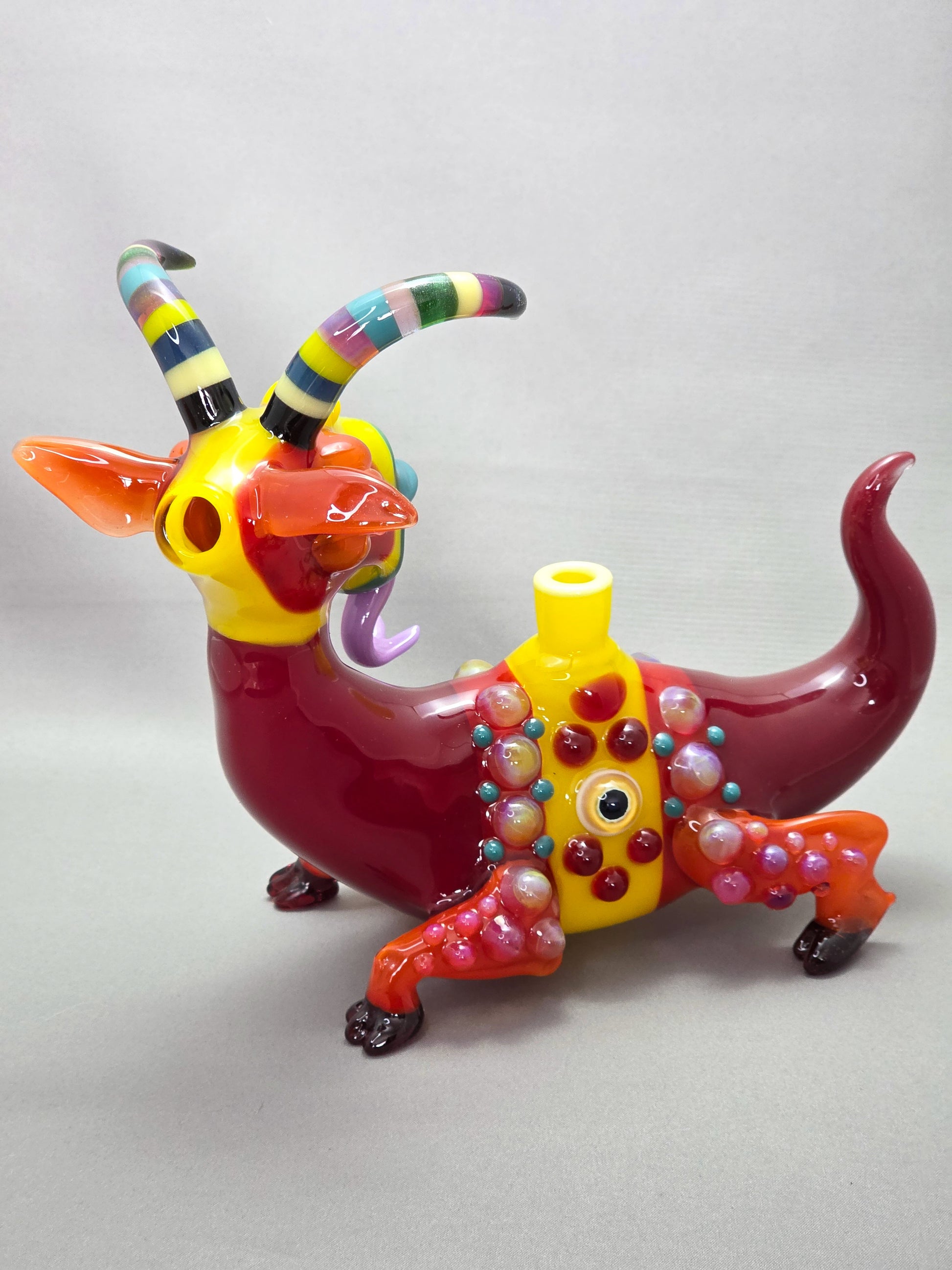 Robertson Glass Colourful glass Goat sculpture on a grey background
