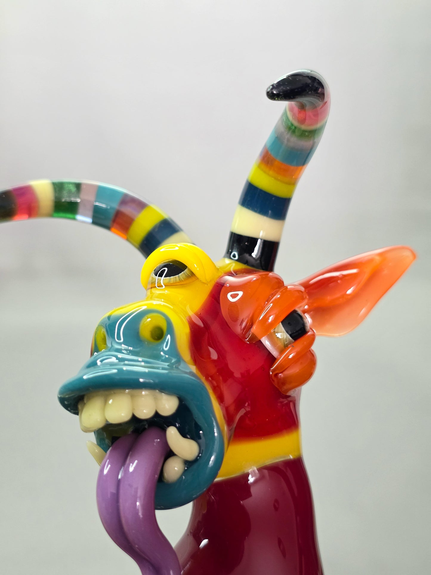 Robertson Glass Colourful glass Goat sculpture on a grey background