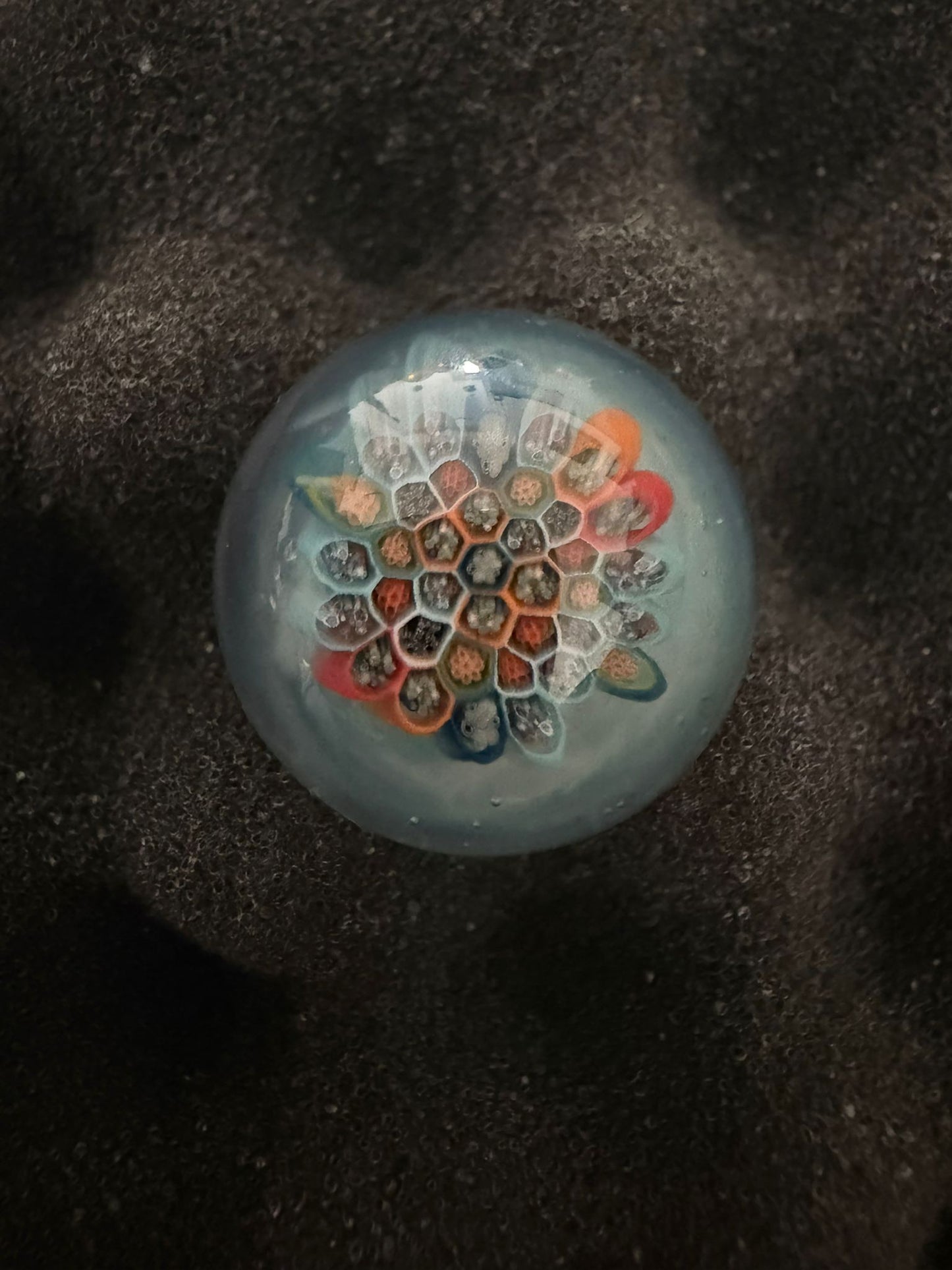 Glass Marble with a character design on a textured black background