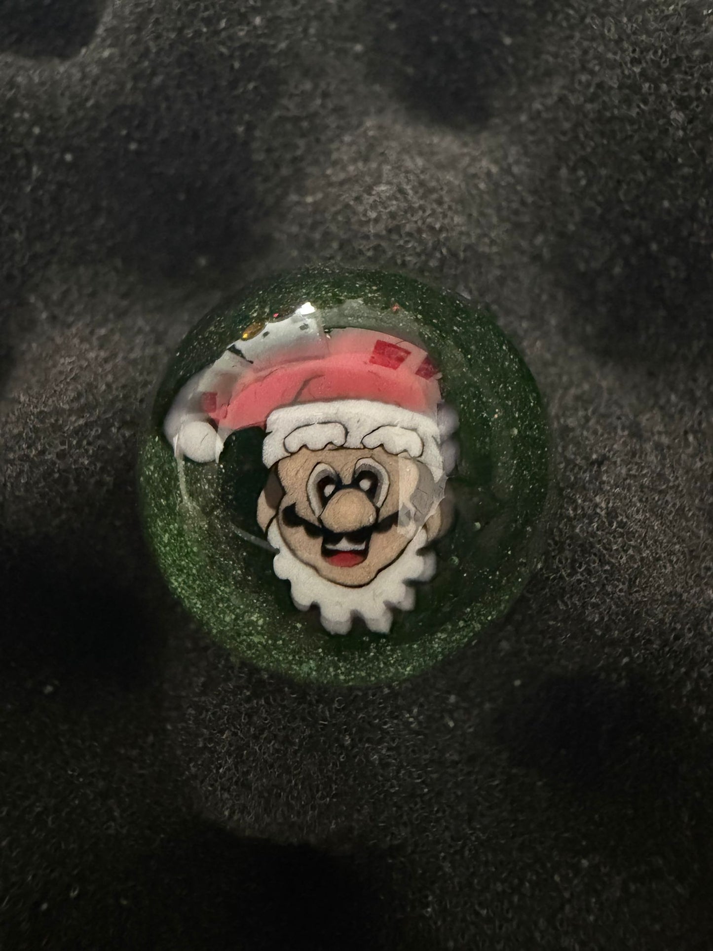 Glass Marble with a character design on a textured black background