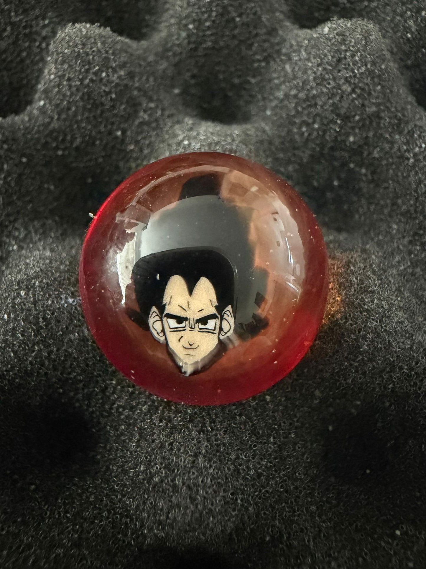 Glass Marble with a character design on a textured black background