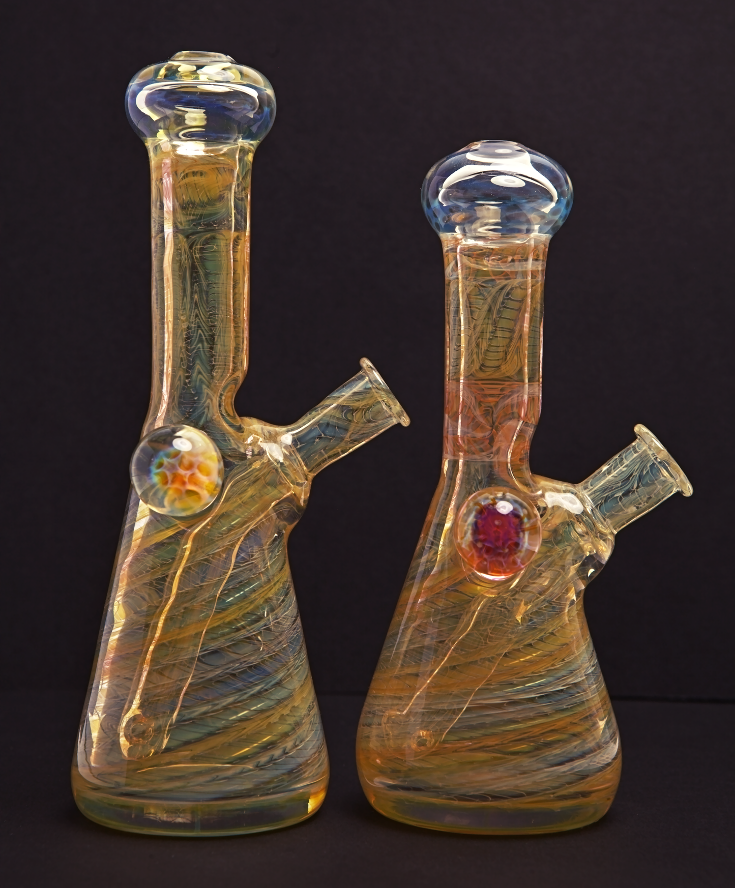 Glass Paradise Two glass beakers with colourful interior patterns on a black background