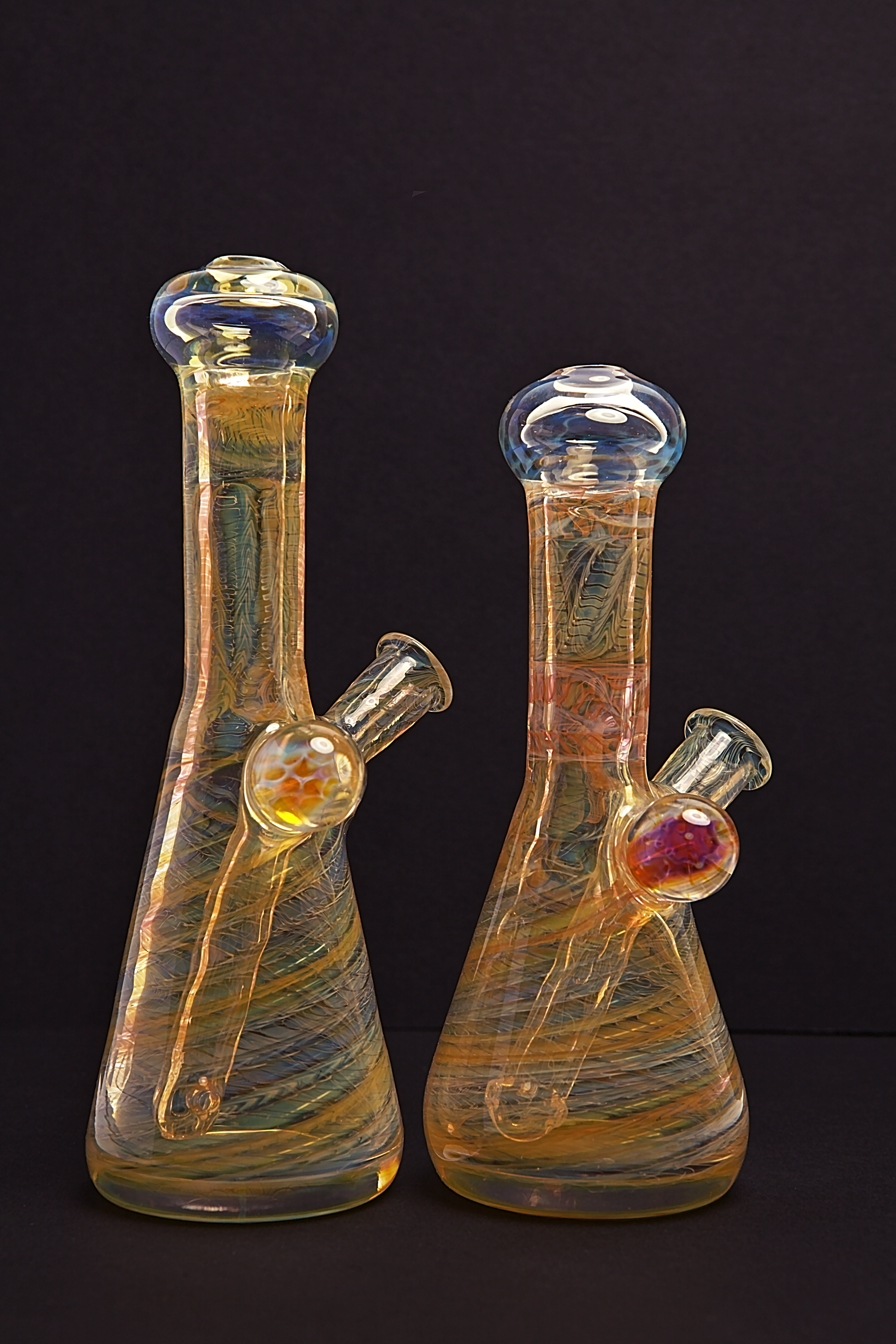 Glass Paradise Two glass beakers with colourful interior patterns on a black background