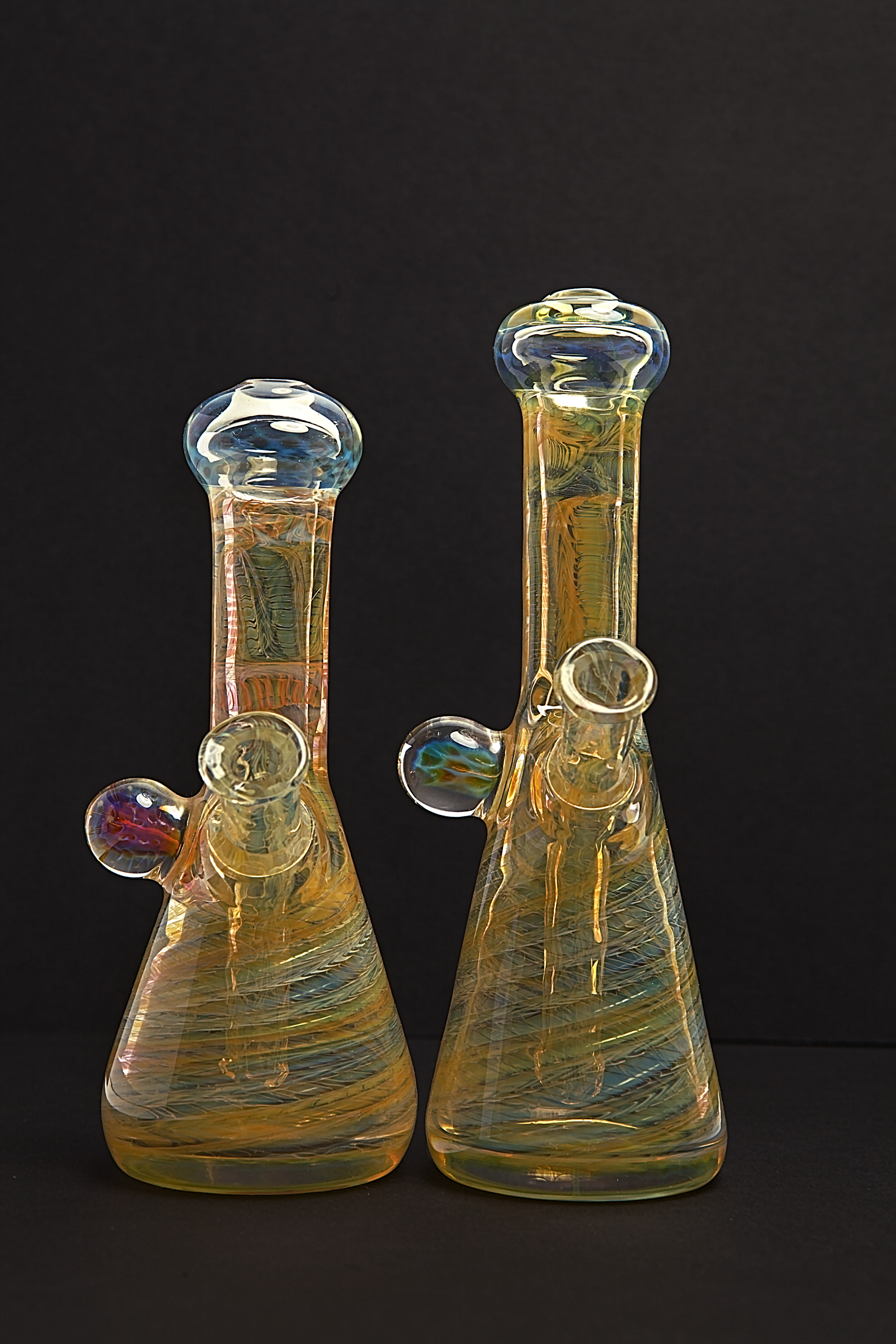 Glass Paradise Two glass beakers with colourful interior patterns on a black background