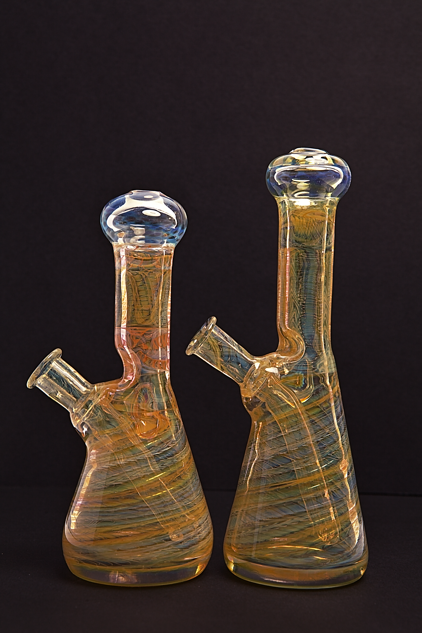 Glass Paradise Two glass beakers with colourful interior patterns on a black background