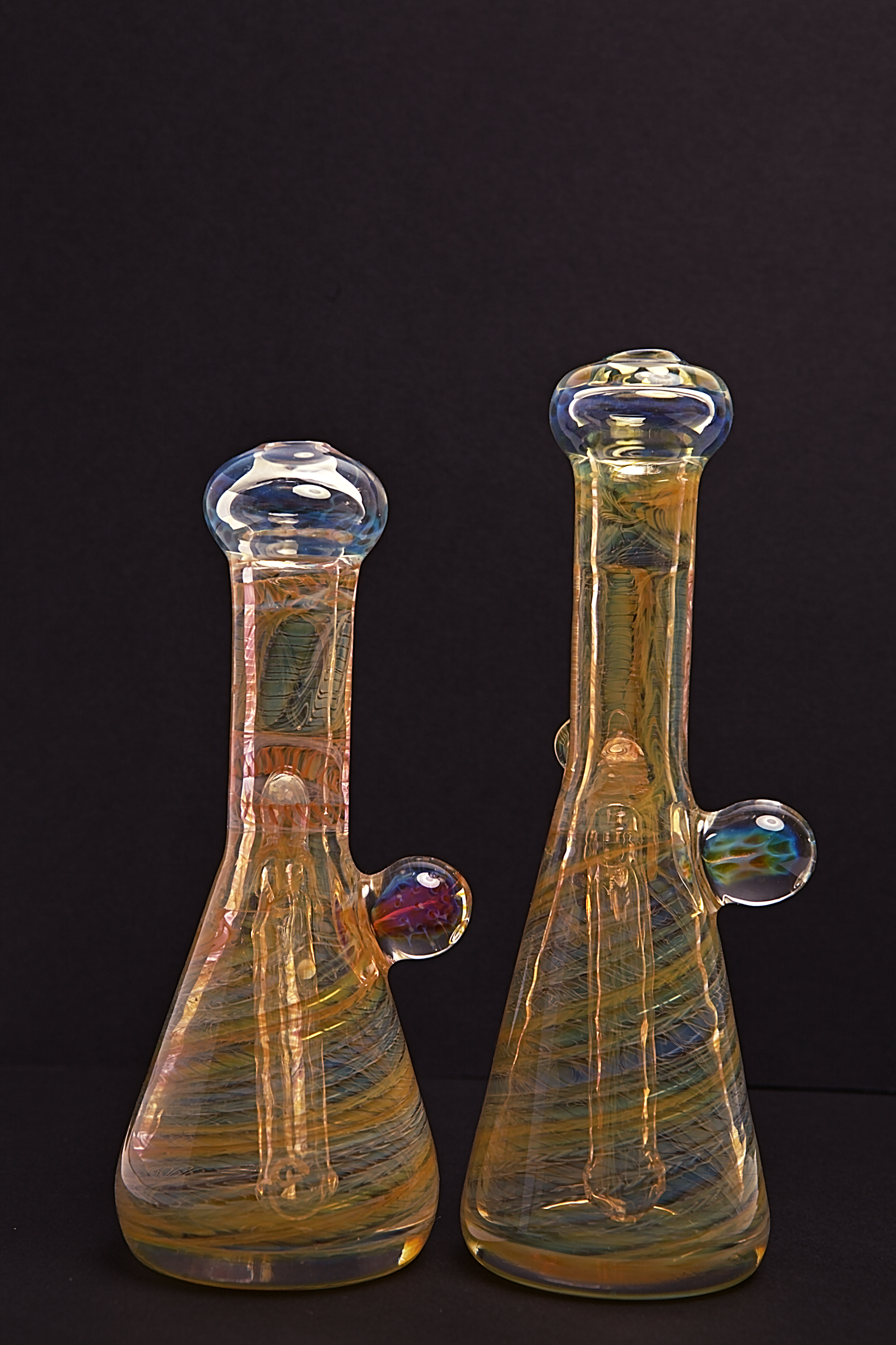 Glass Paradise Two glass beakers with colourful interior patterns on a black background