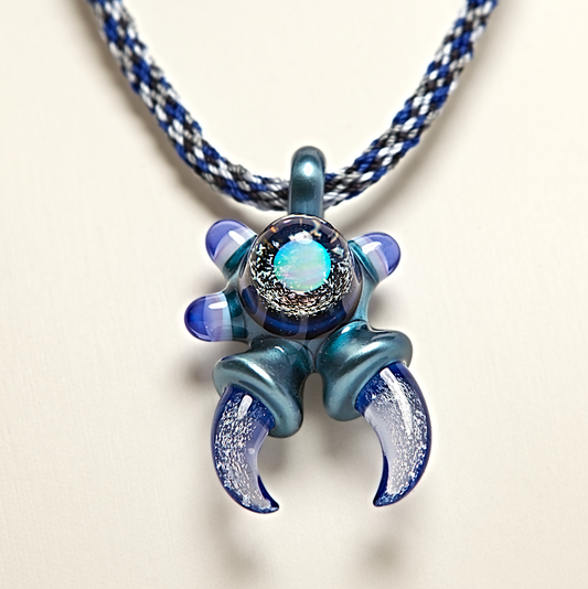 Blue and silver crab-shaped pendant on a white background