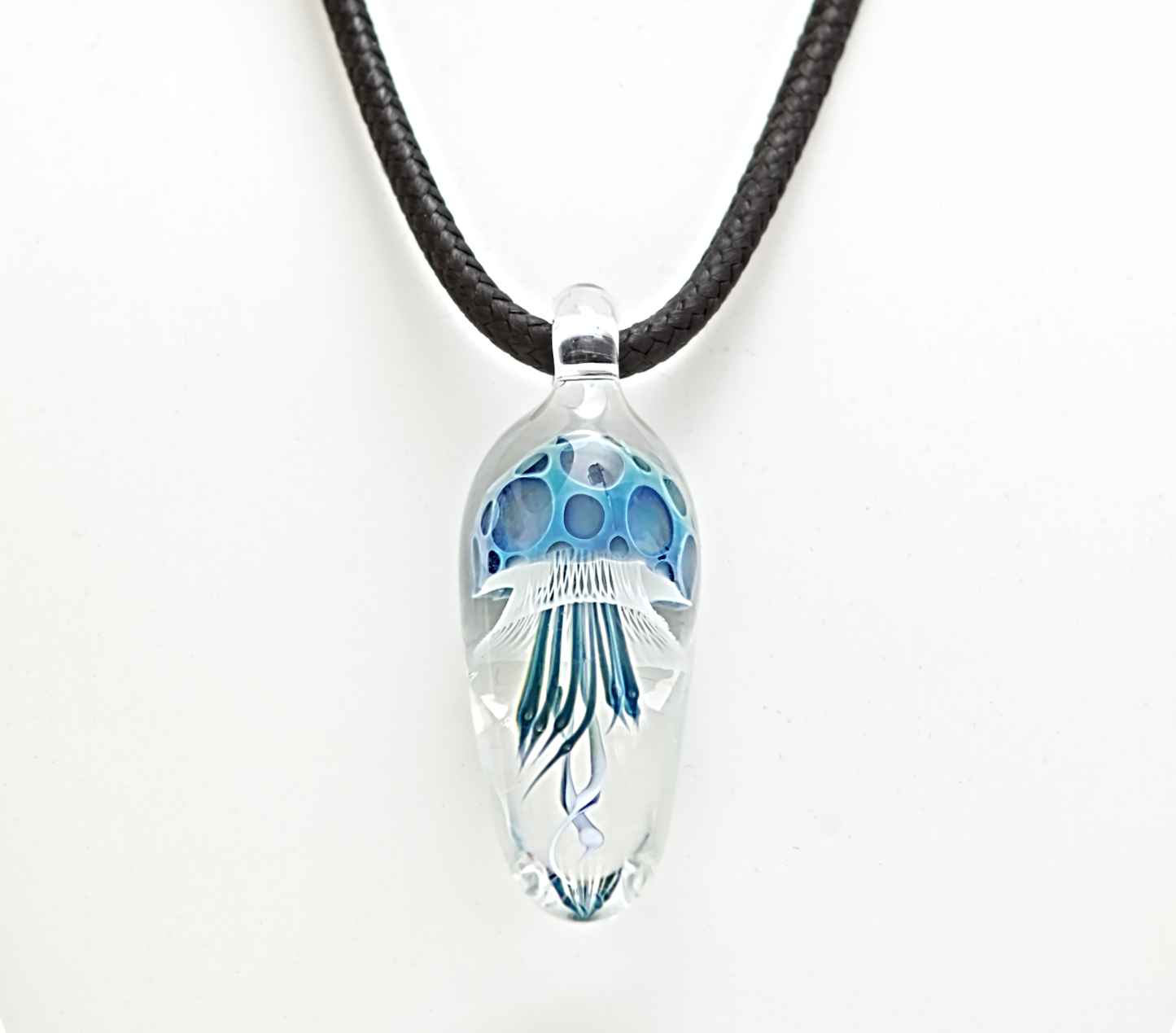 Clear pendant with blue design on a black cord against a white background