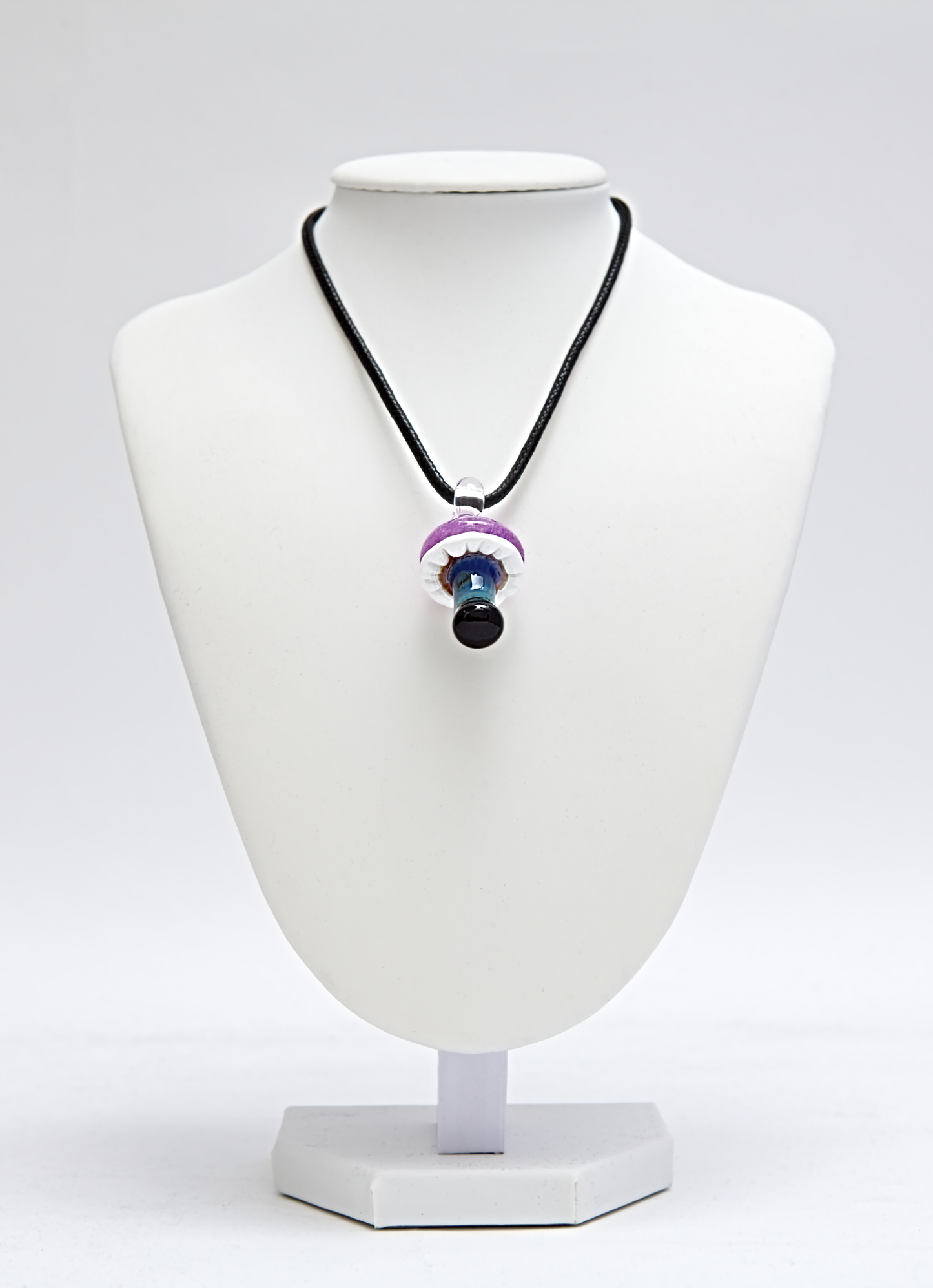 Necklace with a colorful pendant on a white mannequin bust