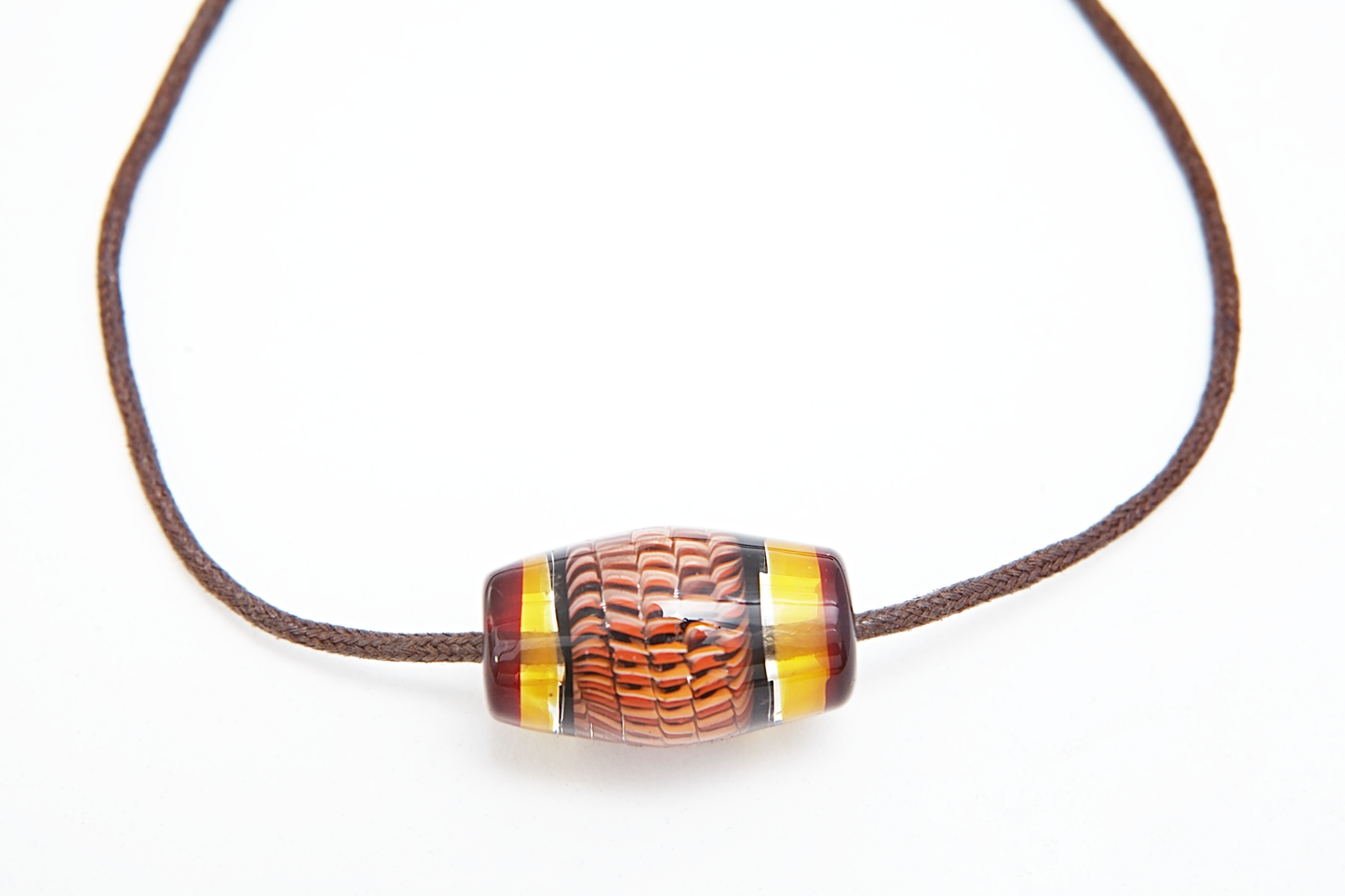 Necklace with a brown and yellow glass pendant on a white background