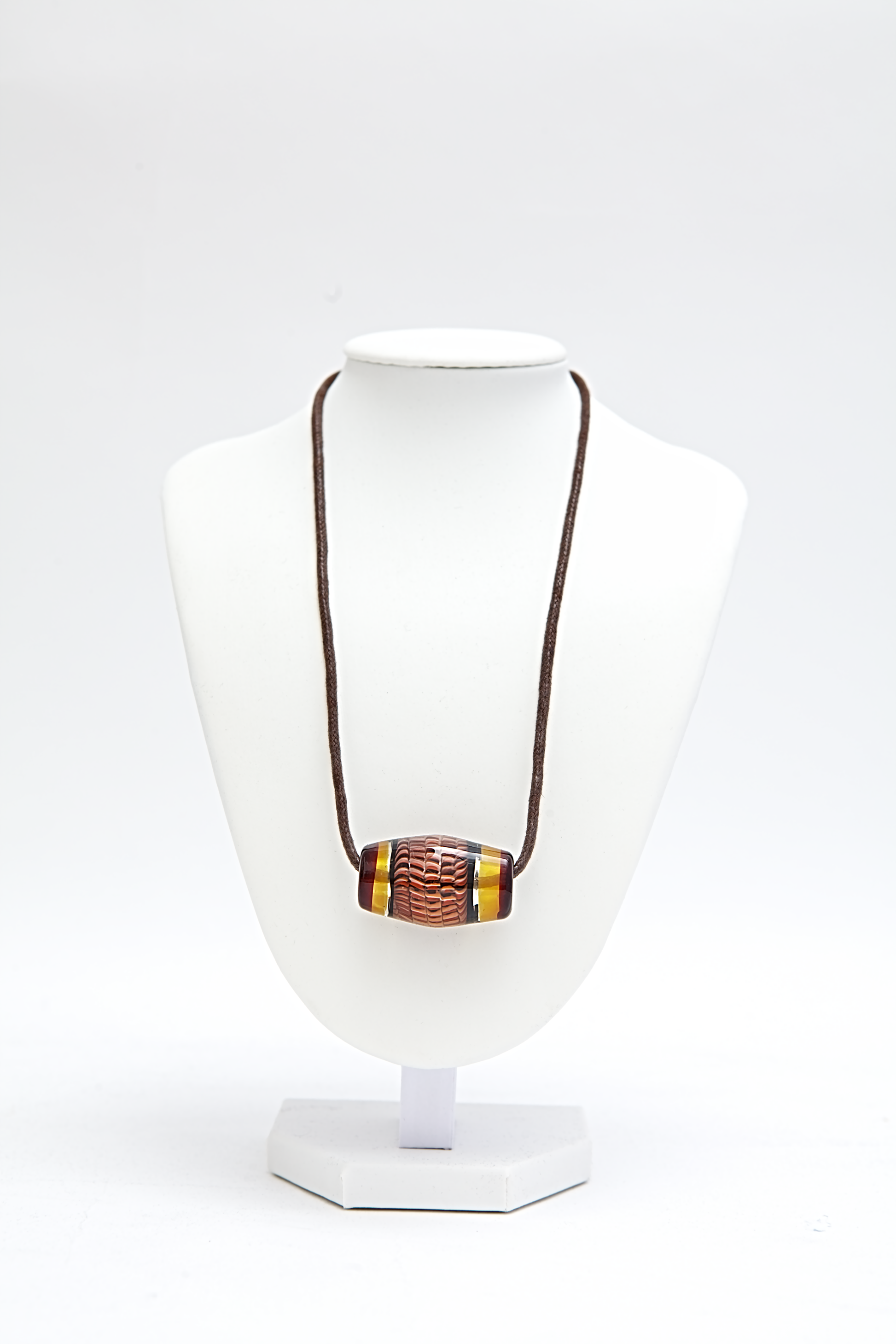 Necklace with a colorful pendant on a white mannequin bust against a white background