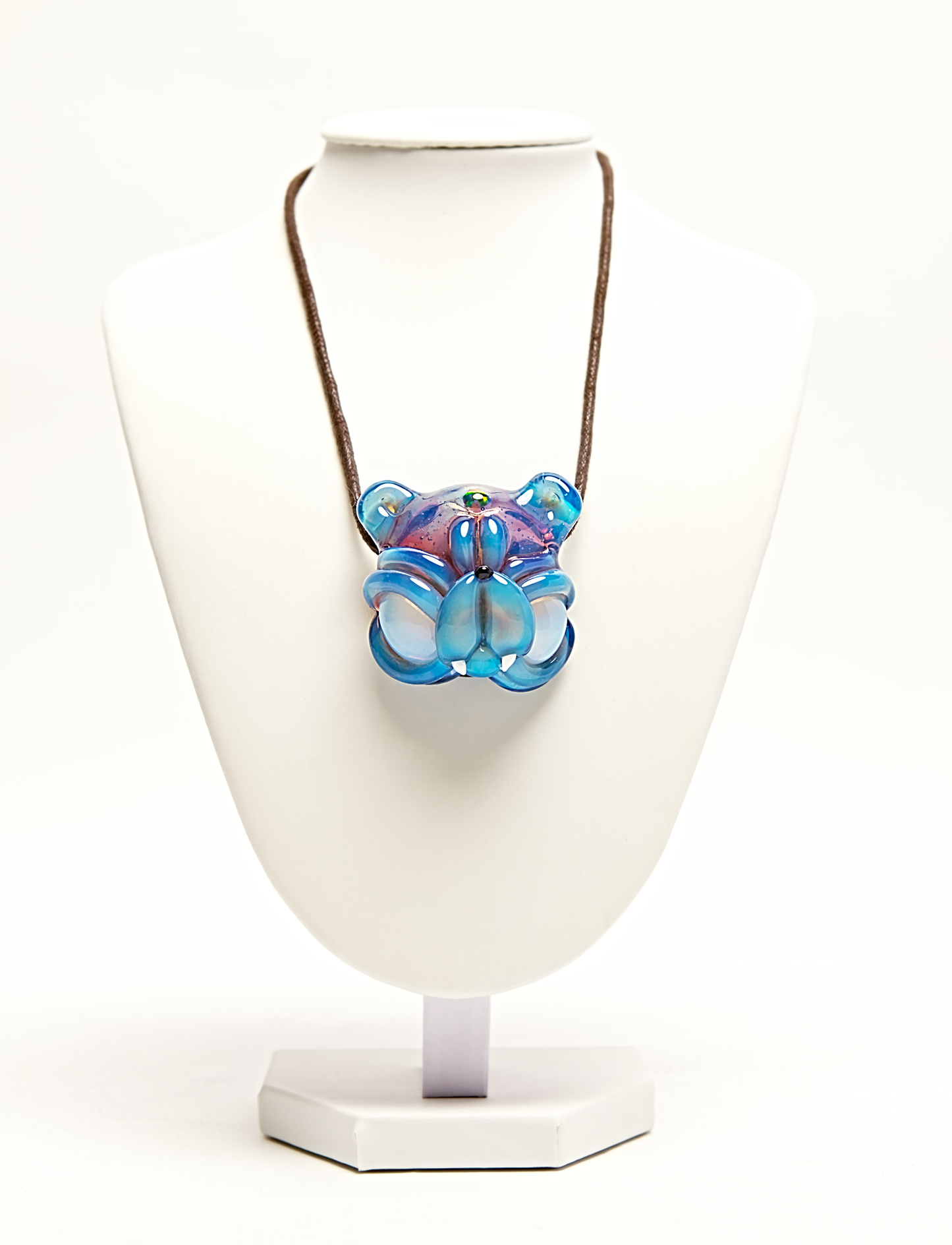 Colorful glass pendant on a white stand with a white background
