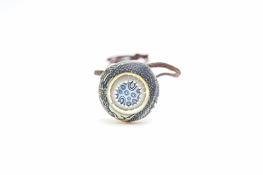 Silver pendant with a circular design on a white background