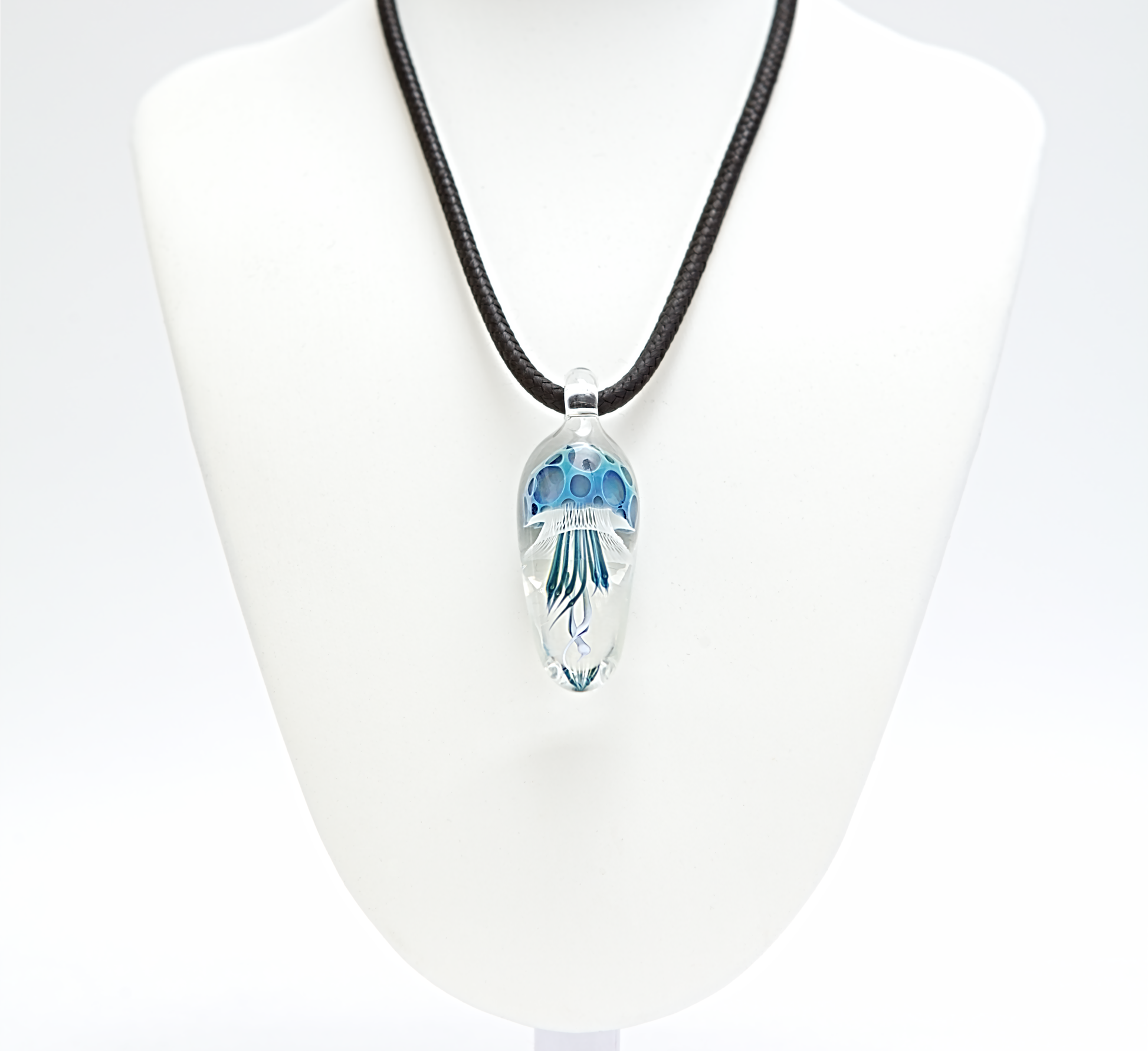 Necklace with a clear pendant featuring blue floral design on a white background